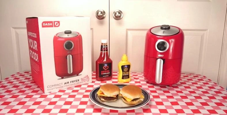 Display image of Dash air fryer with cooked hamburgers