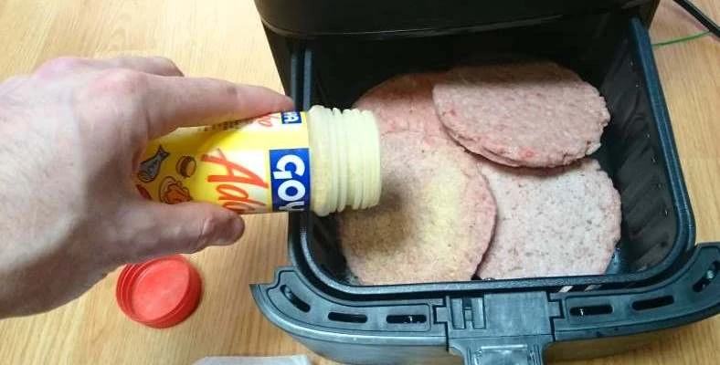 Image showing adding seasoning to frozen patties in air fryer before cooking